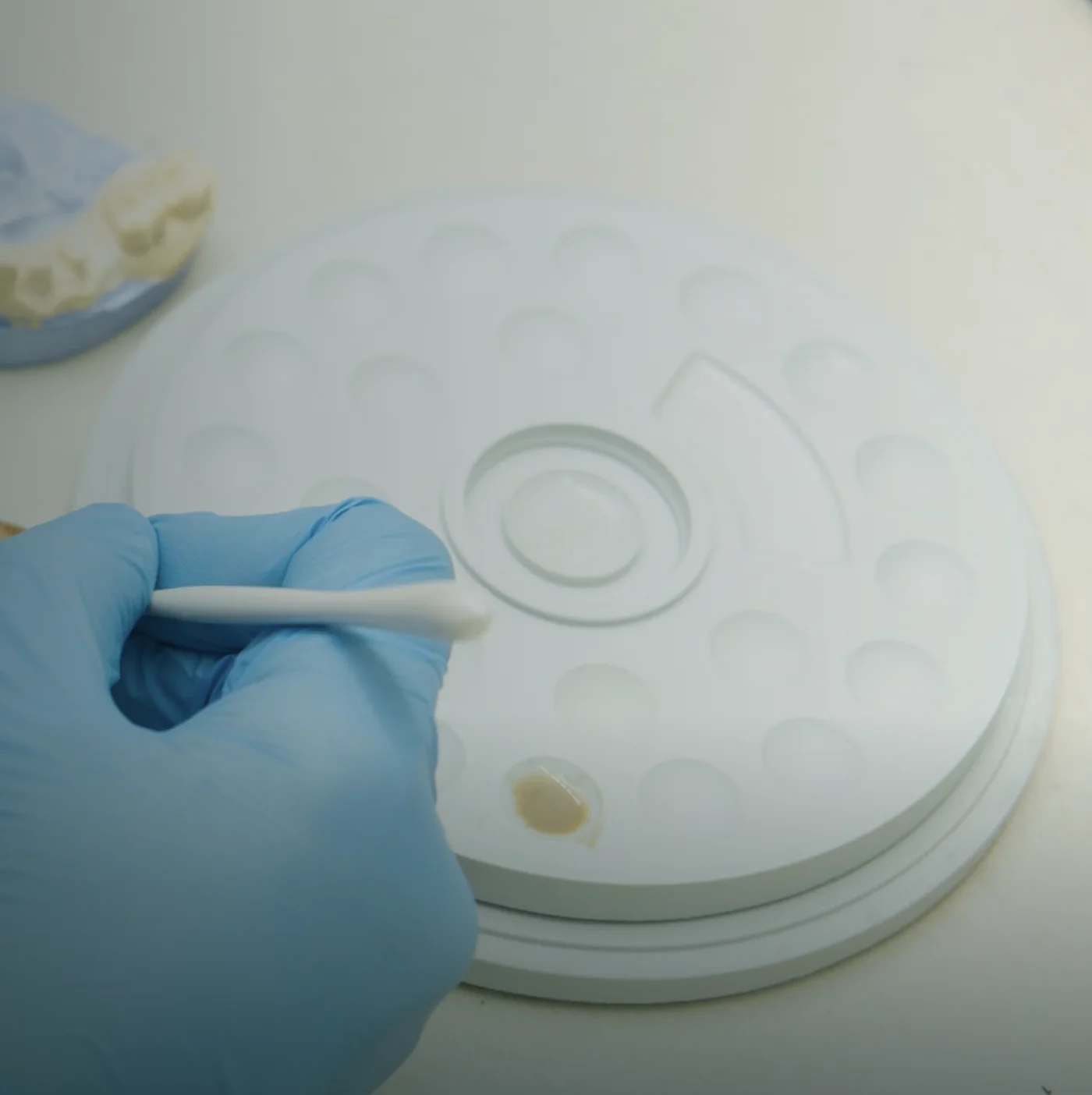 Dental technician working with ceramic at a lab bench